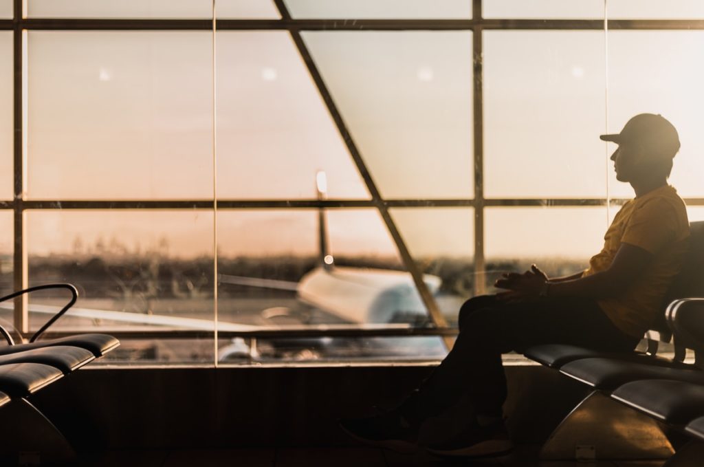 man sitting on gang chair near window